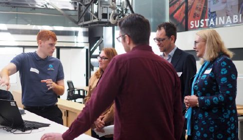 Australian Spatial Analytics employee stands in front of a computer explaining his work to a group of four onlookers including White Box Enterprises CEO Luke Terry