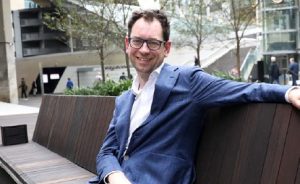Luke Terry, White Box Enterprises CEO sitting on a wooden seat near Barangaroo