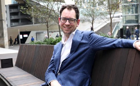 Luke Terry, White Box Enterprises CEO sitting on a wooden seat near Barangaroo