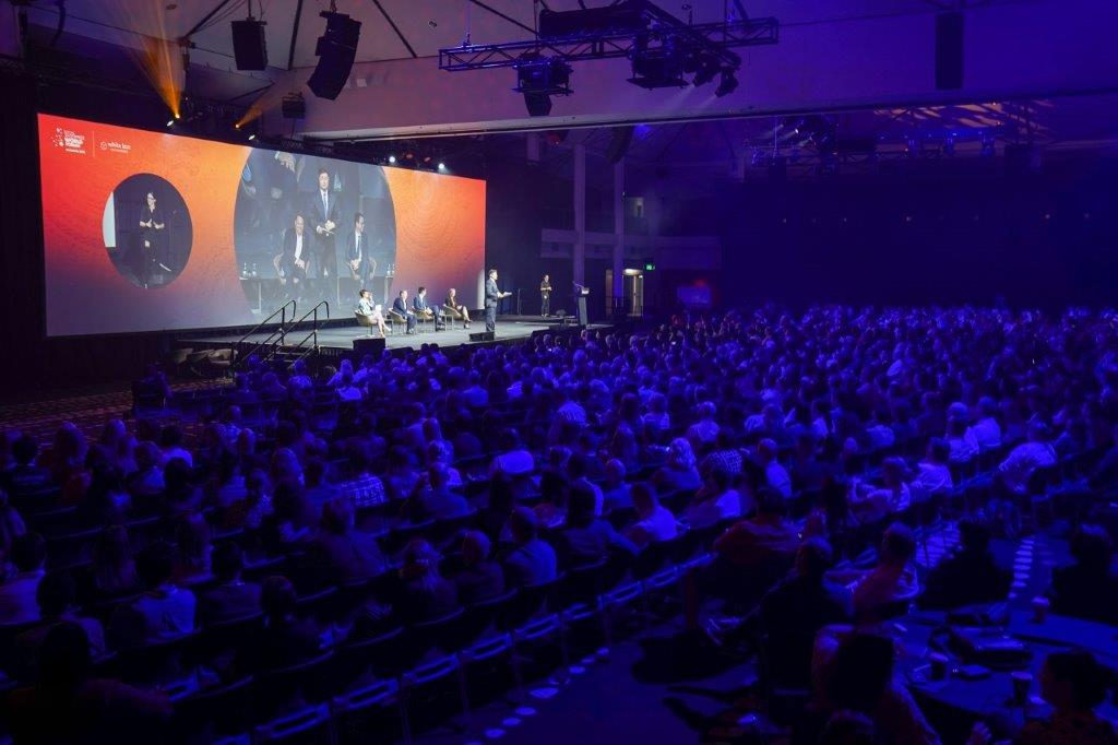 An image taken from the back of the audience of the main stage at the Social Enterprise World Forum where a panel discussion is taking place