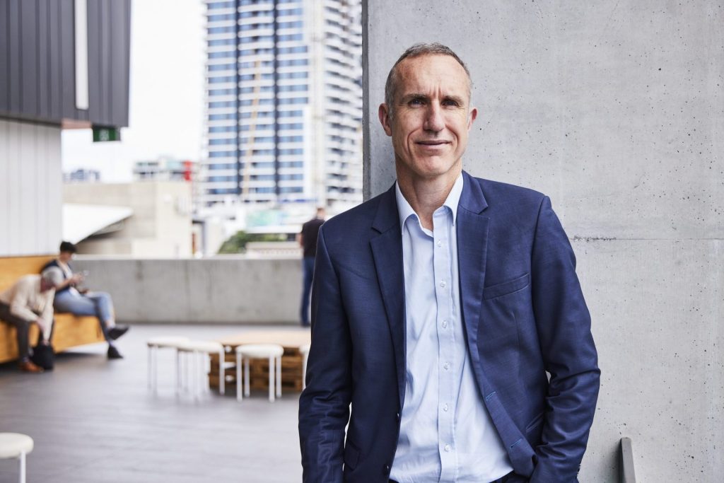 White Box Enterprises' COO, Mark Daniels standing on an outdoor terrace with office buildings in the background