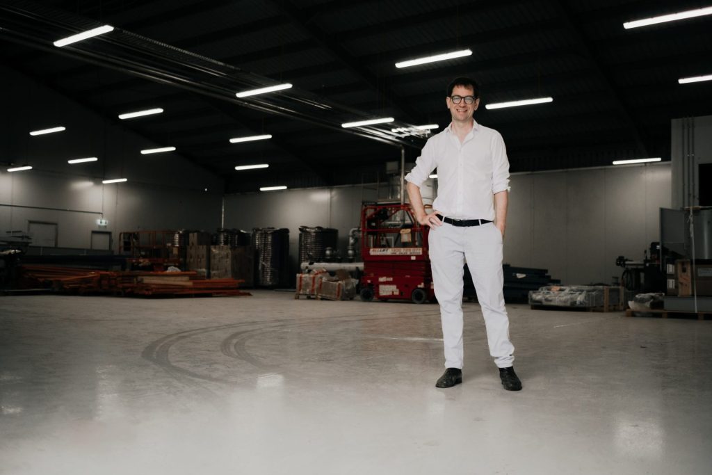 Luke Terry standing in a warehouse space in front of equipment