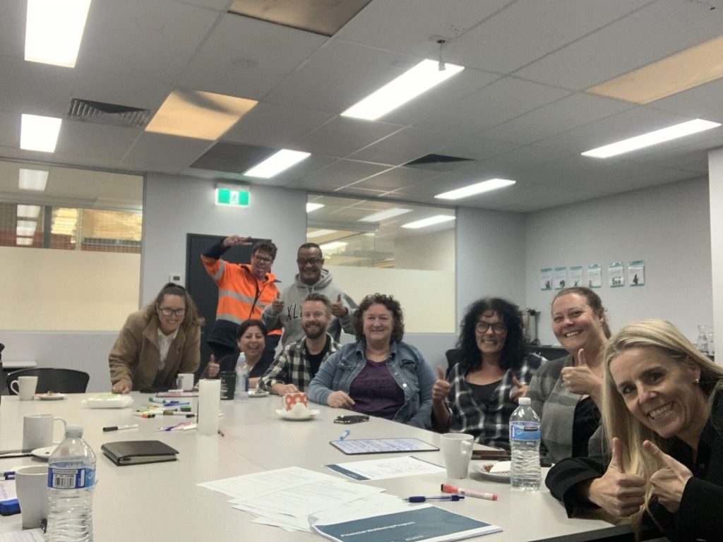 White Box Financial Wellbeing Program workshop participants around a table smiling.